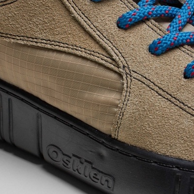 Sapatilha desportiva masculina bege com sola preta e atacadores azuis com pontos vermelhos