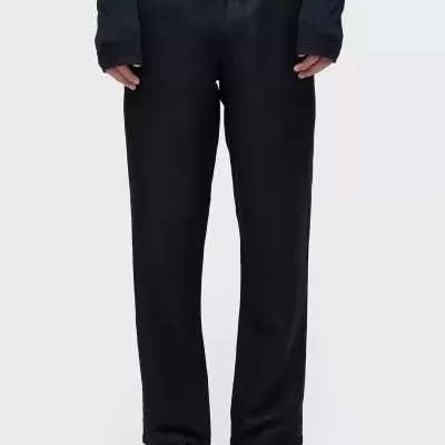 Calças pretas com corte reto usadas com ténis pretos