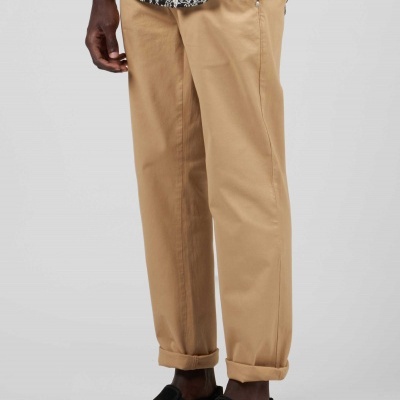 Calças bege com camisa padrão e sapatos pretos sem atacadores