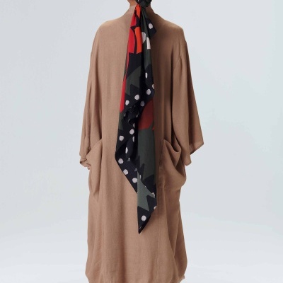 Casaco comprido bege, lenço colorido na cabeça, sandálias prateadas