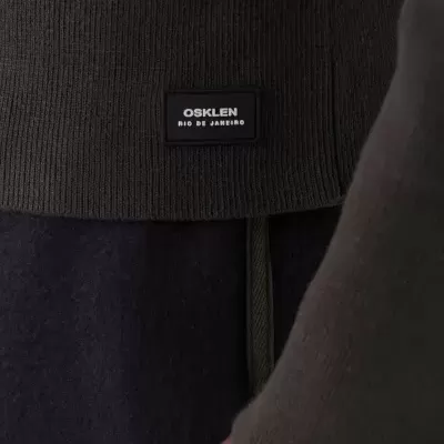 Peça de roupa castanha em malha com etiqueta OSKLEN RIO DE JANEIRO