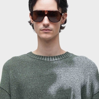 Óculos de sol castanhos com lentes escuras em pessoa com camisa cinzenta