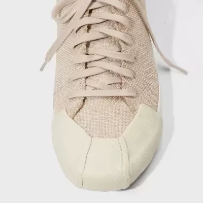 Tênis bege com biqueira branca e atacadores