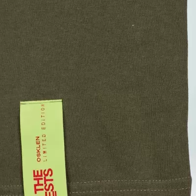 Parte inferior de peça de vestuário castanha com etiqueta verde fluorescente