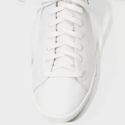 Ténis branco com atacadores e sola ondulada visto de cima