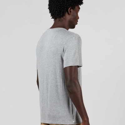 Homem de costas a usar t-shirt cinzenta de manga curta com calças bege