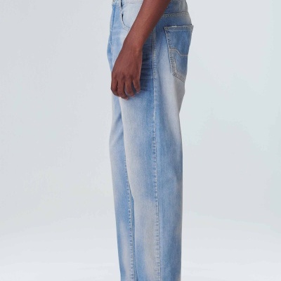 Calças de ganga azuis claras com corte reto e bainha crua usadas por pessoa de perfil