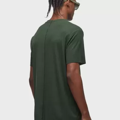 Camiseta verde escura vista de costas com costura vertical e pessoa com óculos verdes