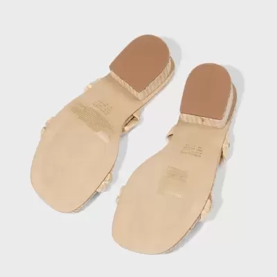 Sandálias femininas com sola bege e salto castanho num fundo cinza claro.