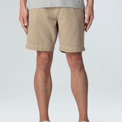 Calções beges estilo chino em modelo com t-shirt cinzenta e sapatilhas brancas e pretas