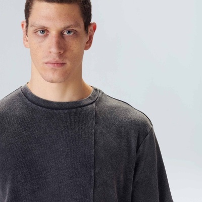 Homem jovem com t-shirt cinzenta de manga curta e fundo branco