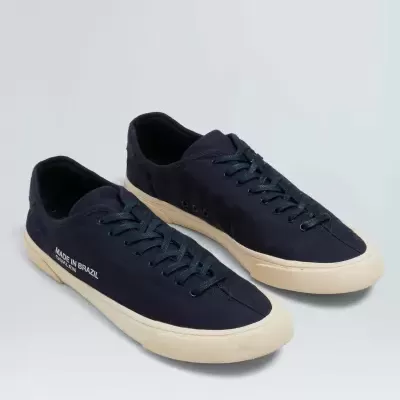 Par de sapatilhas pretas com sola branca e texto 'MADE IN BRAZIL' na lateral