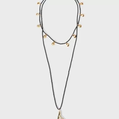 Colar duplo com contas pretas e pendentes dourados em forma de conchas e um pendente dourado em formato de ramo