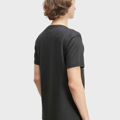 Pessoa de costas com t-shirt preta de manga curta e calças pretas