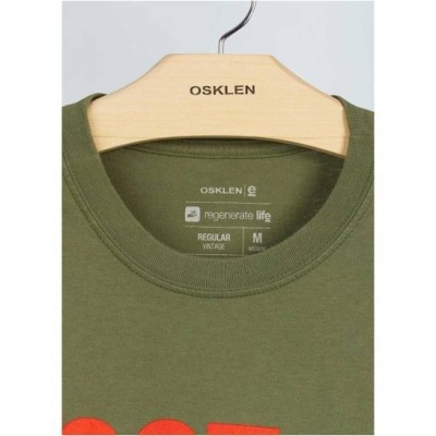 Camiseta verde Osklen com gola redonda pendurada num cabide de madeira com o nome da marca