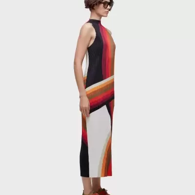 Vestido midi plissado com padrão colorido abstrato usado por mulher de perfil