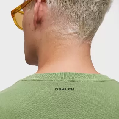 T-shirt verde com logo OSKLEN nas costas, vista de costas