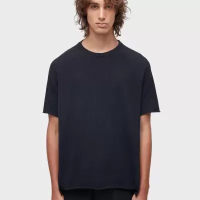 T-shirt preta de manga curta em tecido liso com modelo em fundo branco