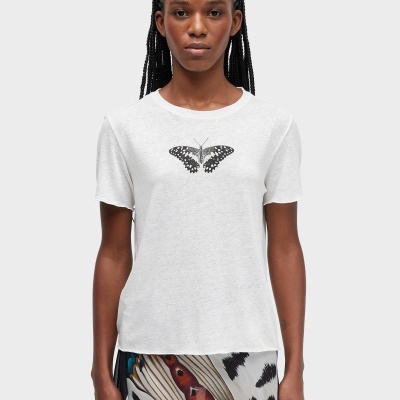 T-shirt branca com borboleta estampada e saia colorida com padrão preto e branco