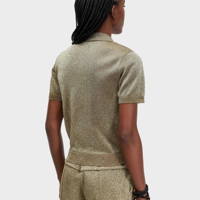 Pessoa de costas com polo dourado de malha brilhante e calças a condizer