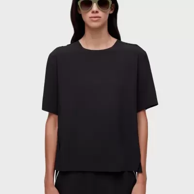 Blusa preta de manga curta com óculos de sol verde claro e fundo cinza