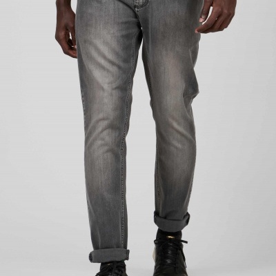 Calças de ganga cinzentas desbotadas com bainhas enroladas usadas em ambiente neutro