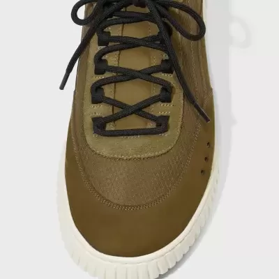 Tênis castanho com atacadores pretos e solado branco visto de cima