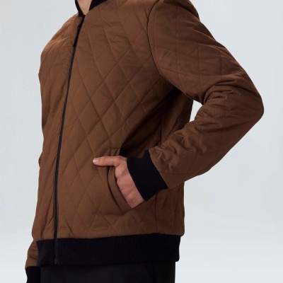 Casaco acolchoado castanho com detalhes pretos usado por modelo