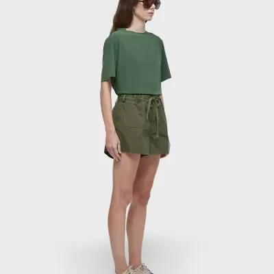 Modelo com t-shirt verde e calções verdes em fundo cinzento
