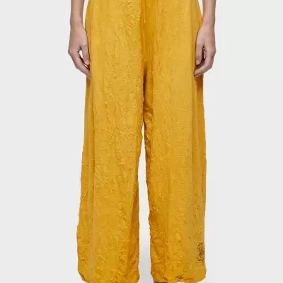 Calças largas amarelas texturizadas com cintura elástica e cordão de ajuste.