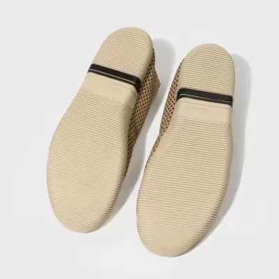 Solas de sapatos baixos em borracha bege com detalhe preto e parte superior em pele perfurada castanho claro