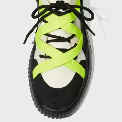 Ténis branco e preto com tiras amarelo-fluorescente cruzadas