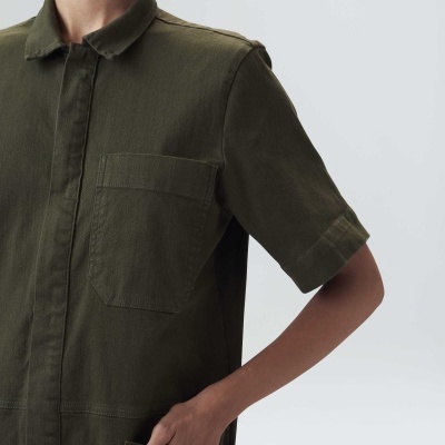 Macacão de manga curta verde-oliva com bolsos e fecho frontal oculto