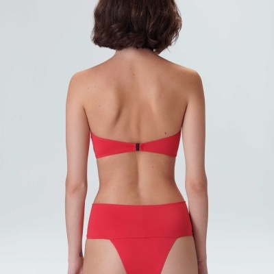 Modelo de costas a usar biquíni vermelho bandeau com fecho prateado e parte de baixo de corte alto
