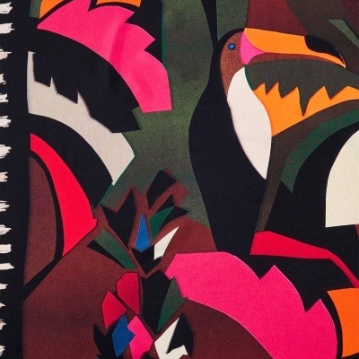 Tecido colorido com padrão gráfico de aves e folhas estilizadas.