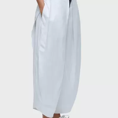 Calças largas brancas com bolsos laterais e sapatilhas brancas