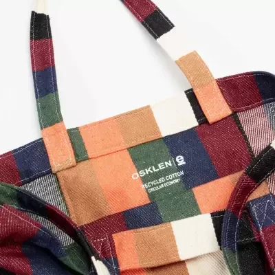 Mochila em tecido com padrão às riscas coloridas e texto branco OSKLEN