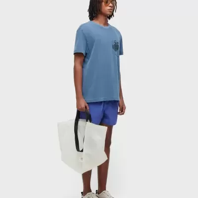 Homem com roupa casual azul e tote bag branca