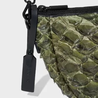 Mala verde com textura que imita escamas e alça preta de couro com zíper
