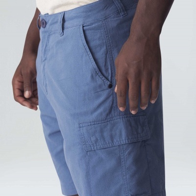 Calções azuis com bolsos laterais usados por homem com pele escura