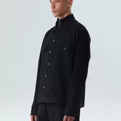 Homem com camisa preta de algodão com botões e bolsos de aba no peito