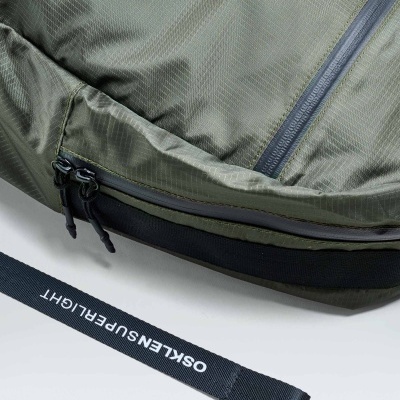 Mochila verde oliva com zíper preto e etiqueta com texto OSKLEN SUPERRLIGHT