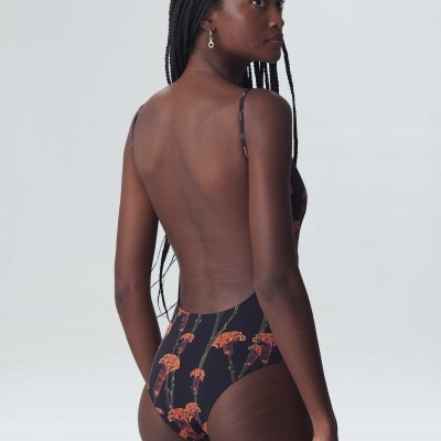 Fato de banho preto com padrão floral usado por mulher vista de costas