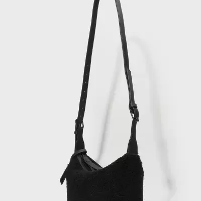 Mala tiracolo preta com textura felpuda e alça ajustável