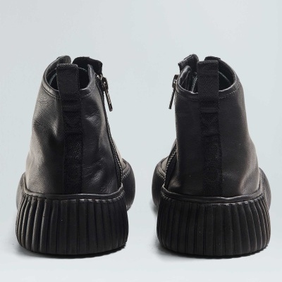 Botas pretas de couro vistas de trás com sola preta grossa