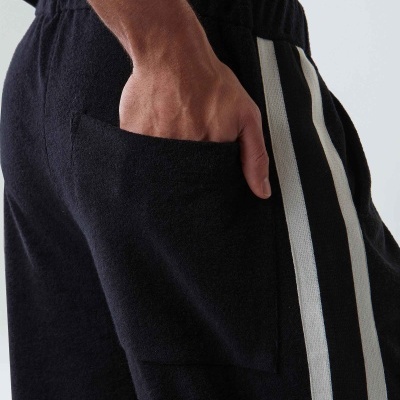 Calças pretas com riscas brancas e bolso traseiro