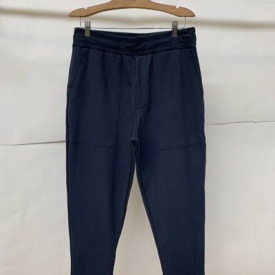 Calças de treino azuis escuras penduradas em cabide de madeira