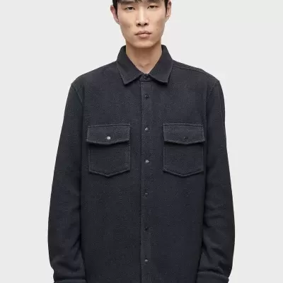 Homem a usar casaco ou camisa preta com bolsos no peito