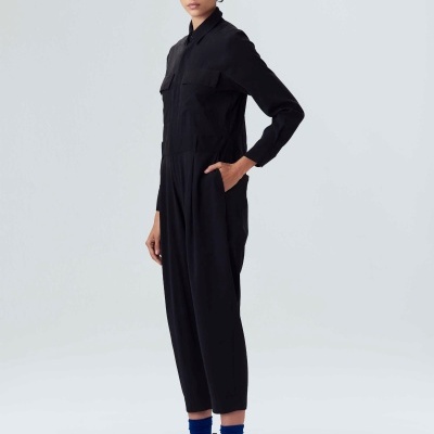 Macacão preto comprido com bolsos usado por modelo em fundo cinza