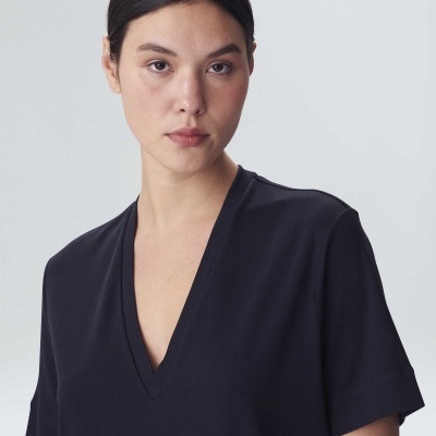 Mulher com blusa preta de decote em V e mangas curtas